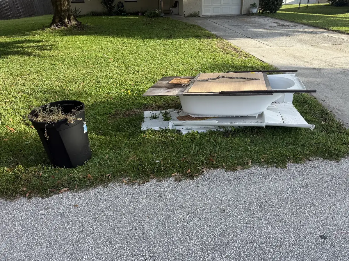Bathtub and renovation debris staged for a curbside pickup